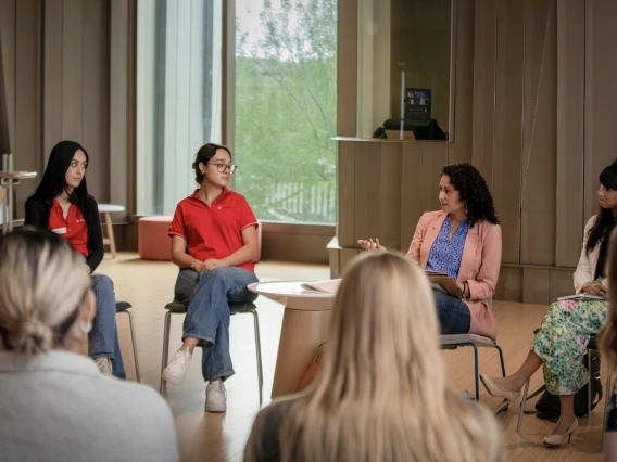 people sitting in chairs in a circle talking