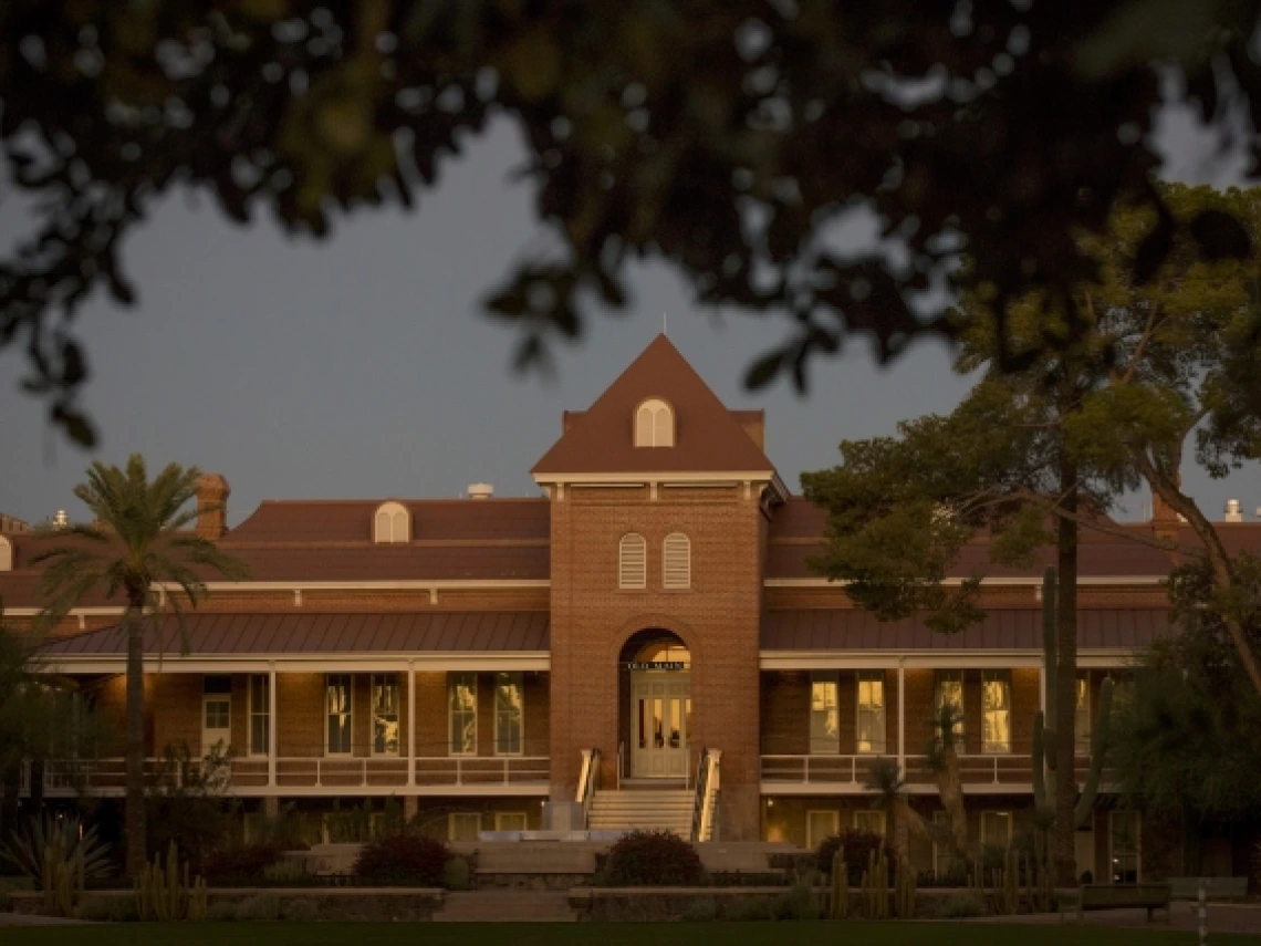 old main at sunset shrouded by trees